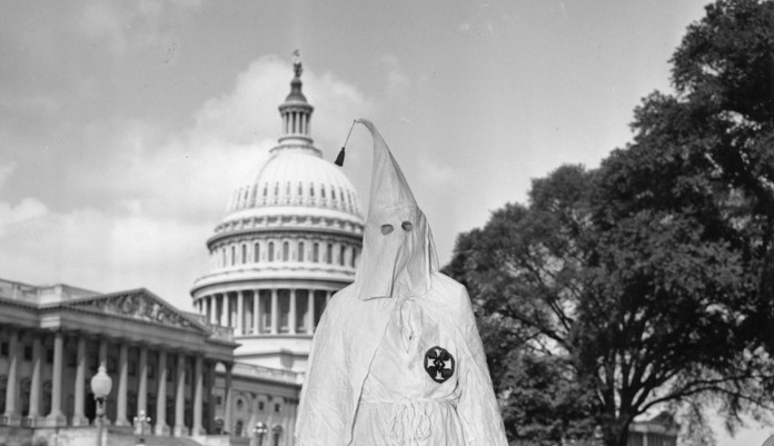 FILE - In this Sept. 10, 1947 file photo, Ku Klux Klan member Stetson Kennedy, 30, of Jacksonville, Fla., walks away from the U.S. Capitol building in Washington. Police had escorted him out of the Un-American Activities Committee room.