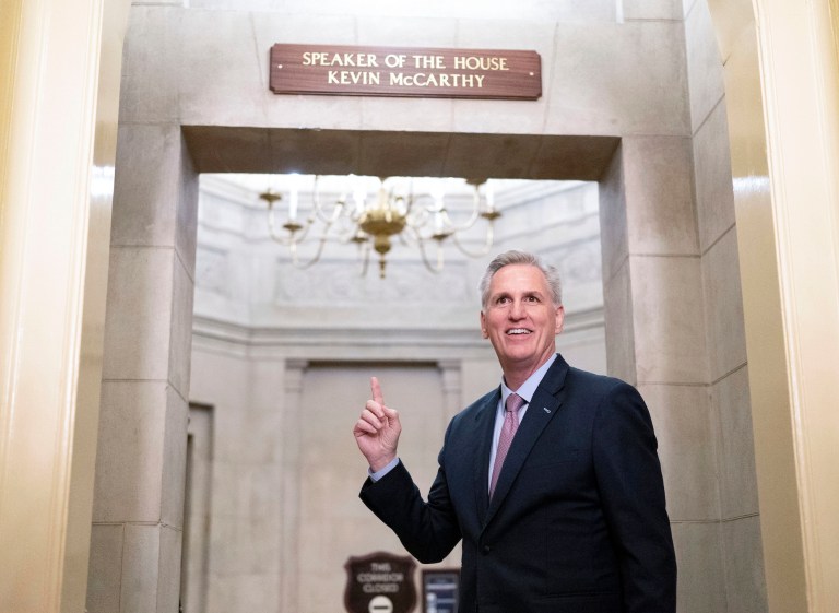 Rep. Kevin McCarthy (R-CA) points to the Speaker of the House sign outside of his new office.