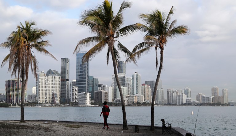 A man fishes in Biscayne Bay, with the skyline of Miami on the horizon, Friday, Feb. 2, 2018, in Miami.
