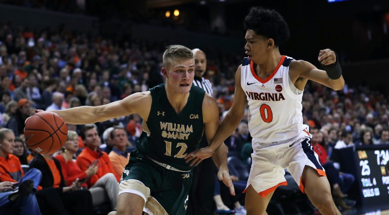 Zack Wajsgras/AP
William and Mary's guard Luke Loewe (12) drives around Virginia's guard Kihei Clark (0) in the first half at John Paul Jones Arena on Saturday. Virginia went into the half with a 34-23 lead.               