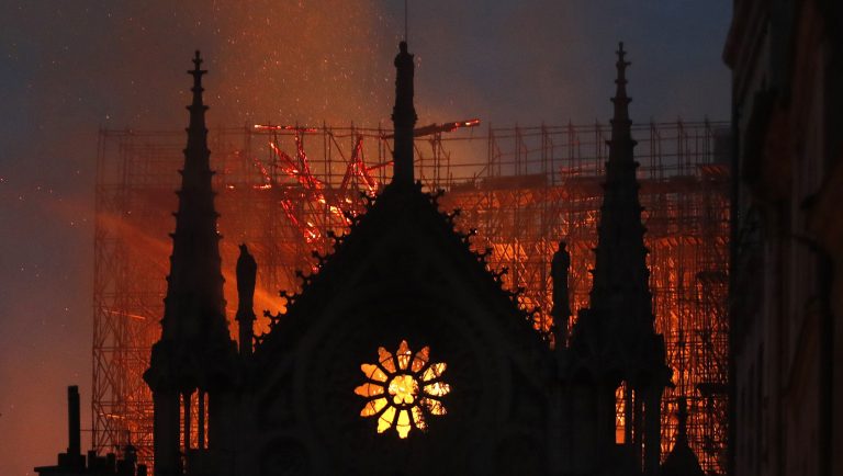 Flames and smoke rise from Notre Dame cathedral as it burns in Paris, Monday, April 15, 2019. Massive plumes of yellow brown smoke is filling the air above Notre Dame Cathedral and ash is falling on tourists and others around the island that marks the center of Paris. 