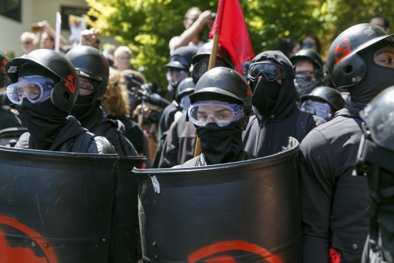 Counter-protesters prepare to clash with Patriot Prayer protesters during a rally in Portland, Ore., Saturday, Aug. 4, 2018. Small scuffles broke out Saturday as police in Portland, Oregon, deployed "flash bang" devices and other means to disperse hundreds of right-wing and self-described anti-fascist protesters.