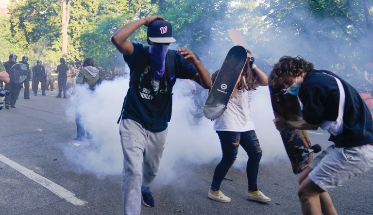 Demonstrators, who had gathered to protest the death of George Floyd, begin to run from tear gas used by police to clear the street near the White House in Washington, Monday, June 1, 2020. Floyd died after being restrained by Minneapolis police officers.