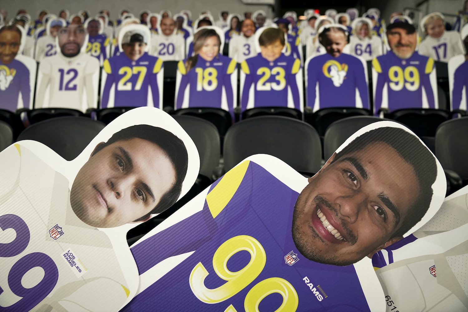 Cutouts of fans occupy some of the stadium seats at an NFL football game.