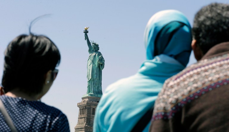 In this May 7, 2015, file photo, people look at the Statue of Liberty from a ferry boat in Jersey City, N.J.