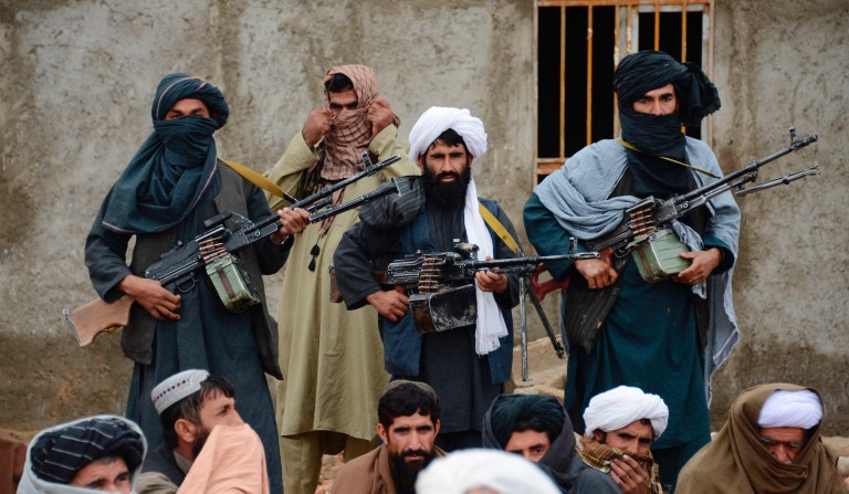 In this Nov. 3, 2015 file photo, Afghan Taliban fighters listen to Mullah Mohammed Rasool, the newly-elected leader of a breakaway faction of the Taliban, in Farah province, Afghanistan.