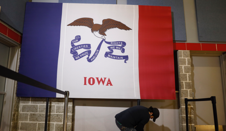A worker sets up an Iowa flag before the arrival of Democratic presidential candidate Sen. Elizabeth Warren at a town hall meeting at Grinnell College, Monday, Nov. 4, 2019, in Grinnell, Iowa. (AP Photo/Charlie Neibergall)