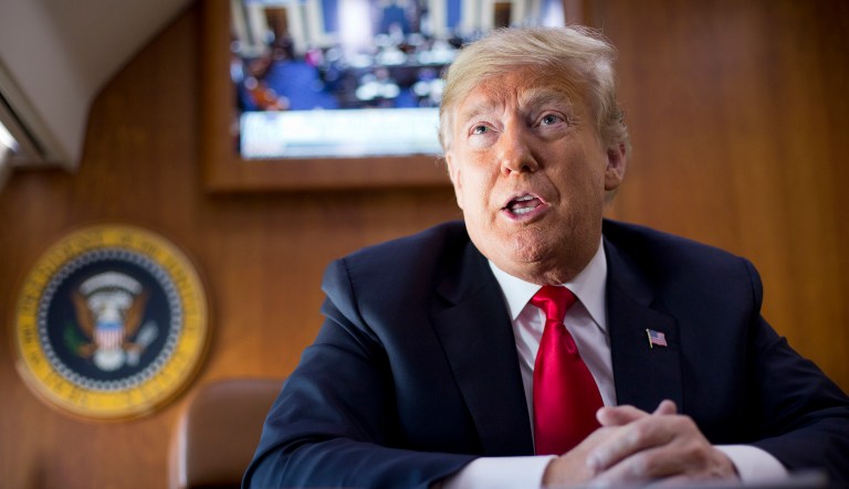 President Donald Trump, on board Air Force One speaks to members of the traveling press corps, as he watches a live television broadcast of the Senate confirmation vote of Supreme Court nominee Brett Kavanaugh, Saturday, Oct. 6, 2018. Trump was traveling from Washington enroute to Topeka, Kan., for a campaign rally.