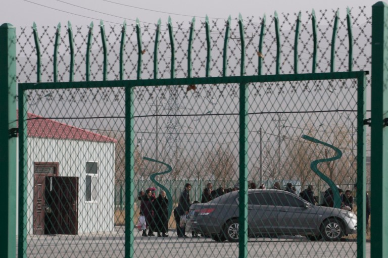 FILE - In this Dec. 3, 2018, file photo, people line up at the Artux City Vocational Skills Education Training Service Center at the Kunshan Industrial Park in Artux in western China's Xinjiang region. (AP Photo/Ng Han Guan, File)