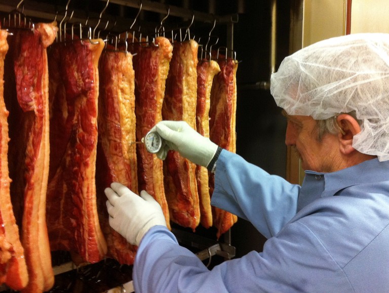In this January 2014 photo provided by Vermont Smoke and Cure, plant manager Don Jutras measures the temperature of bacon hanging in the company's smokehouse in Hinesburg, Vt. Food entrepreneurs in the state have added at least 2,162 new jobs and 199 new businesses since 2009, according to a 2013 annual report of Farm to Plate, an initiative to boost the food and farm economy in Vermont. The report says food manufacturing grew the most. (AP Photo/Vermont Smoke and Cure)