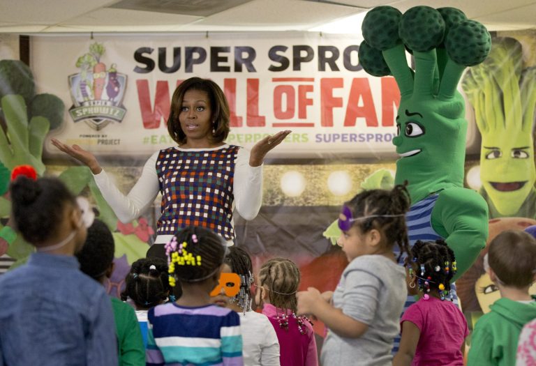 First lady Michelle Obama talks to the kids after they exercised and danced with the Super Sprowtz during a visit to La Petite Academy in Bowie, Md., Thursday, Feb. 27, 2014, to promote healthy environments and encouraging healthy habits at preschools as part of her Let's Move! Child Care program. (AP Photo/Carolyn Kaster)