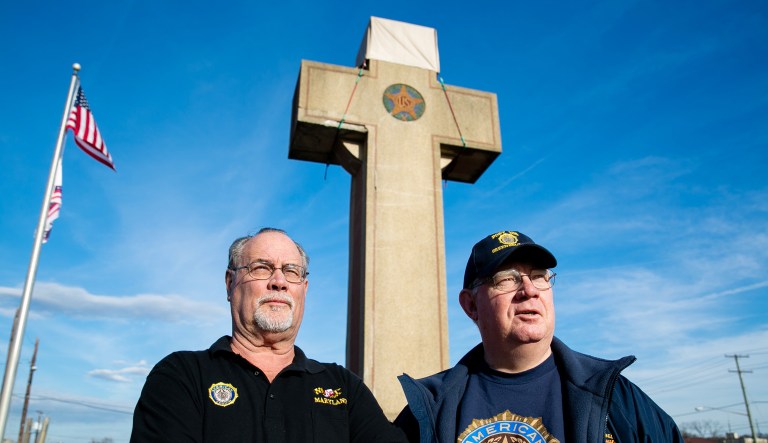 Two American Legion members stand near the Peace Cross in Maryland.