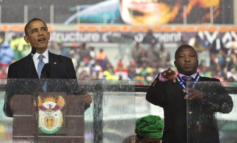 President Barack Obama speaks during a memorial service for Nelson Mandela at FNB Stadium in Soweto, Johannesburg, whileÃÂ Thamsanqa Jantjie interprets in sign language, on Tuesday.ÃÂ (AP Photo/Evan Vucci, File)