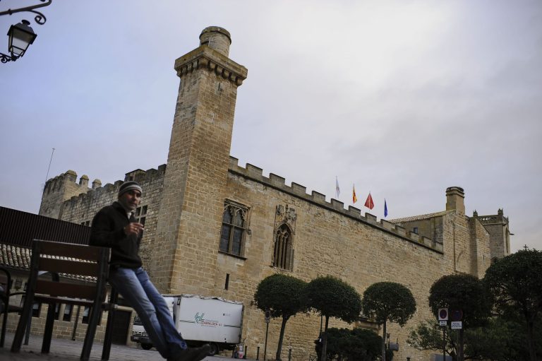   A man rests beside at parador hotel of Principe de Viana, in Olite, northern Spain on Friday, Dec. 7, 2012. Employees of Spain's premium hotel chain Parador, a state-run group that uses castles, monasteries and palaces, are holding a two-day strike to protest job cuts and possible closures. The Parador hotels group, which started in 1928, says a drop in demand could leave it with accumulated losses of euro107 million ($140 million) by the end of the year. It intends to cut 644 jobs out of a workforce of 4,400. (AP Photo/Alvaro Barrientos)  