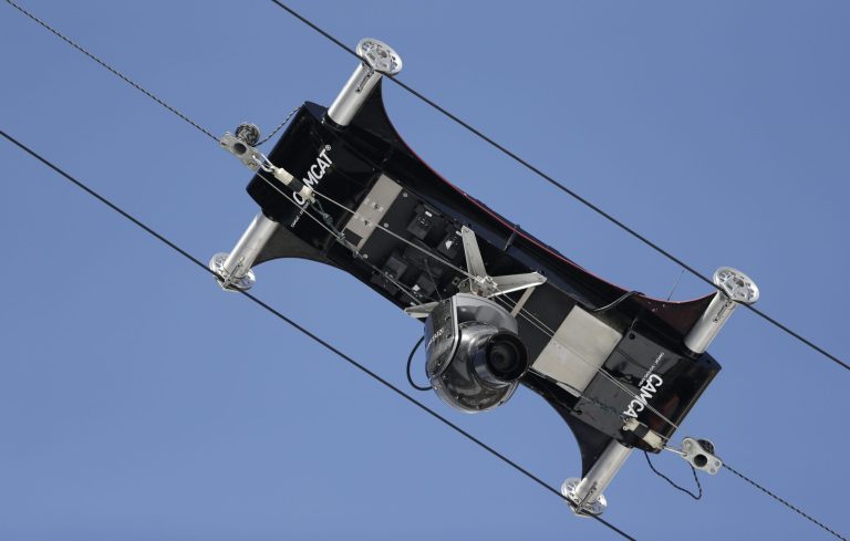 A spider camera records the nordic combined training in the ski jumping stadium at the 2014 Winter Olympics, Monday, Feb. 10, 2014, in Krasnaya Polyana, Russia. (AP Photo/Matthias Schrader)