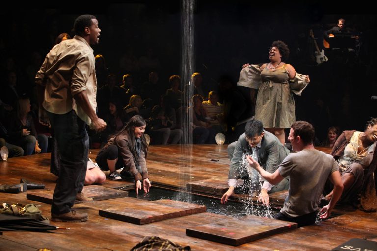   In this theater image released by The Publicity Office, Wallace Smith, standing left, and Celisse Henderson, standing right, are shown with the company in a scene from 