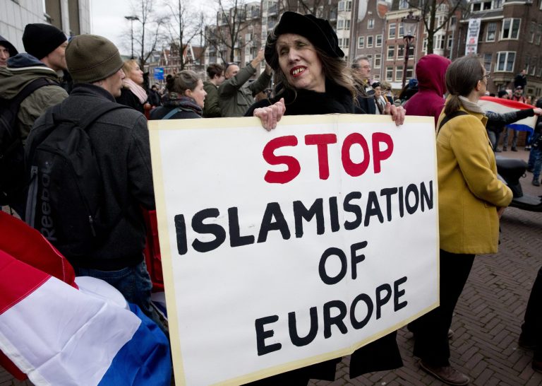 In this Feb. 6, 2016 file picture a woman holds a placard during a Pegida demonstration against immigration and Islamisation in Amsterdam, Netherlands. World migration is up, and the U.S. has the most. (AP Photo/Peter Dejong)