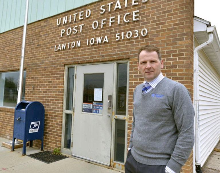 Heath Mallory, general manager of Western Iowa Telephone,  stands outside the post office in Lawton, Iowa, Thursday April 24, 2014. With post office closing at 2 p.m. on weekdays Mallory says it is harder to get mailings out before closing.  (AP Photo/The Sioux City Journal, Tim Hynds)