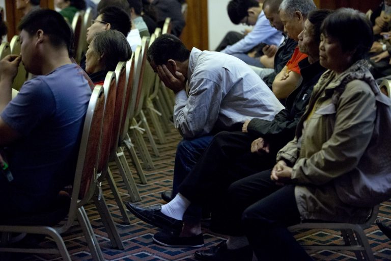 Relatives of Chinese passengers onboard the missing Malaysia Airlines Flight 370 listen, as part of the audio communications between Flight 370's cockpit and air traffic controllers is played, during a meeting with Malaysian officials at a hotel in Beijing, China, Wednesday, April 30, 2014. The Australian agency heading up the search for the missing Malaysian jet has dismissed a claim by a resource survey company that it found possible plane wreckage in the northern Bay of Bengal.  (AP Photo/Alexander F. Yuan)