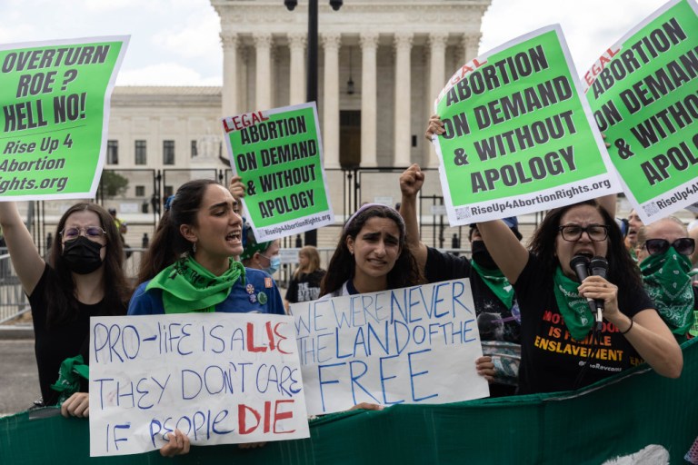 Pro-abortion rights protesters use signs and other items in opposition to the overturning of Roe v. Wade on Friday in Washington.