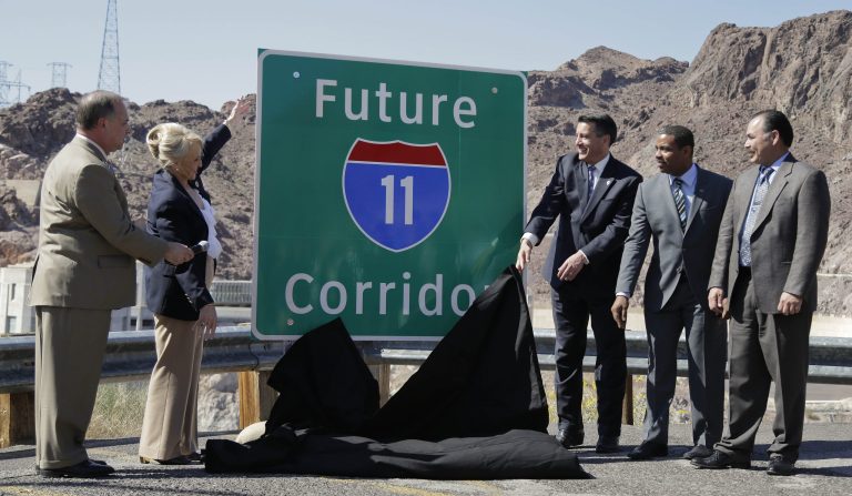 From left, Arizona Department of Transportation director John Halikowski, Arizona governor Jan Brewer, Nevada governor Brian Sandoval, Steven Horsford, D-Nev., and Nevada Department of Transportation director Rudy Malfabon unveil a sign that will mark the corridor for the future Interstate 11 between Phoenix and Las Vegas, Friday, March 21, 2014, at Hoover Dam, Ariz.  It was a symbolic effort meant to keep up momentum on the project, which is coming of age in an era of scarce highway funding. (AP Photo/Julie Jacobson)
