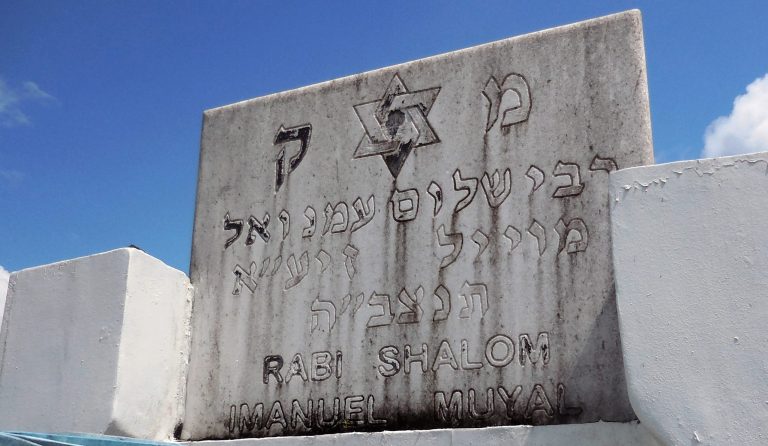 The tombstone of Rabbi Shalom Imanuel Muyal, who died of yellow fever in 1910, stands above his tomb at the Saint John the Baptist Cemetery in Manaus, Friday, June 20, 2014. Local Christians in the Amazonian city have made it a tradition to turn up at Muyal's burial spot in the Saint John the Baptist Cemetery to pray for miracles. (AP Photo/Chris Lehourites)