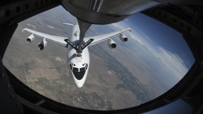 United States Navy Boeing E-6B Mercury is framed by the window of a KC-135R Stratotanker while refueling in a turn high over Colorado Aug. 23, 2019. 