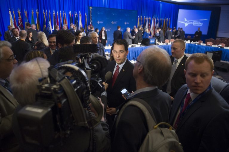 Wisconsin Gov. Scott Walker, center, talks to reporters at the conclusion of the opening session of the National Governors Winter Meeting in Washington, Saturday, Feb. 21, 2015. (AP Photo/Cliff Owen)