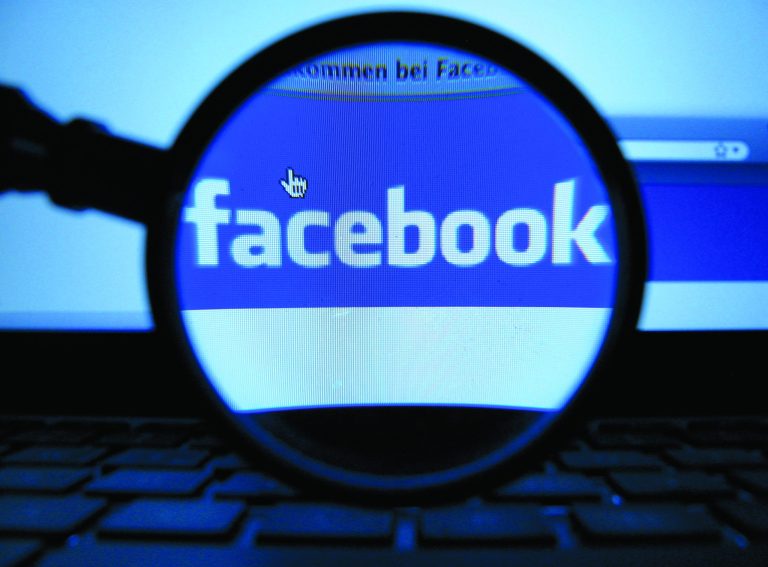 FILE - In this Oct. 10, 2011 file photo, a magnifying glass is posed over a monitor displaying a Facebook page in Munich. Facebook is proposing to end its practice of letting users vote on changes to its privacy policies, though it will continue to let users comment on proposed updates. The world's biggest social media company said in a blog post Wednesday, Nov. 21, 2012, that its voting mechanism, which is triggered only if enough people comment on proposed changes, has become a system that emphasizes quantity of responses over quality of discussion. Users tend to leave one or two-word comments objecting to changes instead of more in-depth responses. (AP Photo/dapd, Joerg Koch, File)