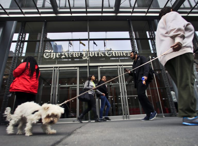 Pedestrians pass the entrance of The New York Times on Wednesday in New York. (AP Photo)