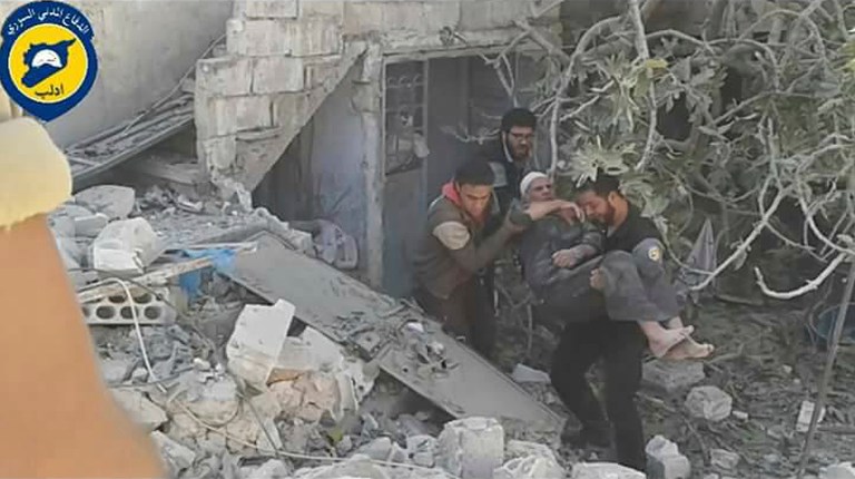 Syrian Civil Defense workers help an injured man after airstrikes in the village of Hass in the Idlib province, Syria, Wednesday, Oct. 26, 2016. (Syrian Civil Defense White Helmets via AP)