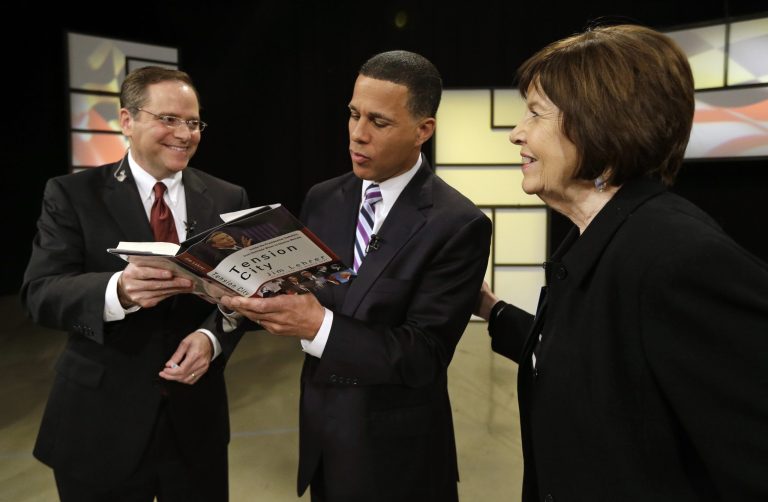 In this June 2, 2014 photo, Democratic gubernatorial candidate, Lt. Gov. Anthony Brown, center, signs a book for moderator Jeff Salkin, left, as Susan Cochran, president of the League of Women Voters of Maryland, watches after a Democratic gubernatorial primary debate in Owings Mills, Md. (AP Photo/Patrick Semansky)