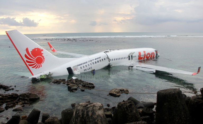 In this photo released by Indonesian Police, the wreckage of a crashed Lion Air plane sits on the water near the airport in Bali, Indonesia on Saturday, April 13, 2013. The plane carrying more than 100 passengers and crew overshot a runway on the Indonesian resort island of Bali on Saturday and crashed into the sea, injuring nearly two dozen people, officials said. (AP Photo/Indonesian Police)