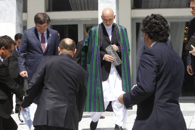   Afghan President Hamid Karzai, center, arrives for a group photo with the foreign attendees of the Asia Ministerial Conference at the foreign ministry in Kabul, Afghanistan, Thursday, June 14, 2012. Afghanistan's neighbors and regional heavyweights met in Kabul on Thursday to do something they rarely do _ try to tackle common threats and problems together.(AP Photo/Musadeq Sadeq)  