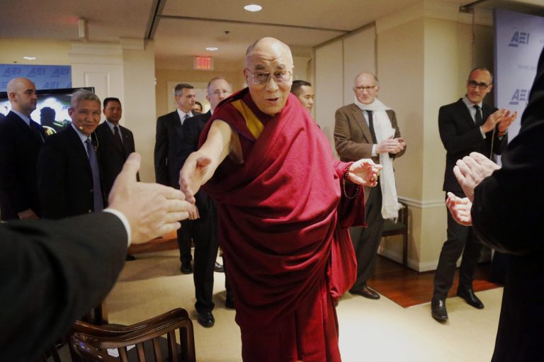 Tibetan spiritual leader the Dalai Lama greets audience members as he arrives to speak at an event entitled: 