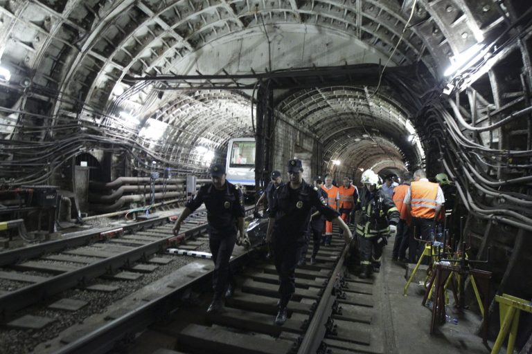 In this photo taken on Tuesday, July 15, 2014 rescuers carry a stretcher with a victim from a tunnel after a train derailed between two subway stations in Moscow, Russia. Investigators detained two Moscow subway workers Wednesday in the wake of the deadly rush-hour derailment that killed at least 22 people and injured 136 others. (AP Photo)