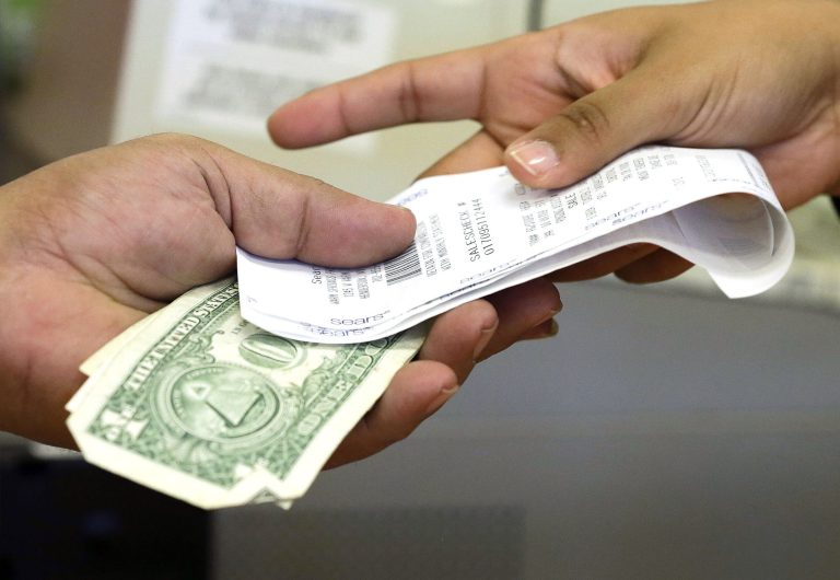 FILE - In this Friday, Nov. 23, 2012 file photo, a cashier hands a customer his change and receipt during a transaction at a Sears store, in Henderson, Nev. Commerce Department releases personal income and spending for July 2014 on Friday, Aug. 29, 2014. (AP Photo/Julie Jacobson, File)