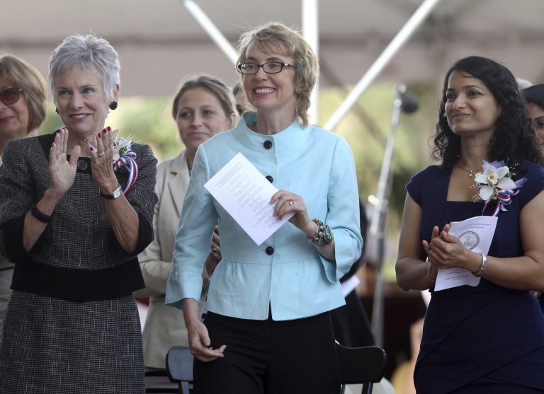   Former Arizona Congresswoman Gabrielle Giffords, center, smiles during the commencement exercises at the United States Merchant Marine Academy in Kings Point, N.Y., Monday, June 18, 2012. Giffords husband, former astronaut Mark Kelly, an alumnus of the academy, was the commencement speaker. Kelly said that he and Giffords have dedicated their lives to public service and urged the graduates to do the same. (AP Photo/Seth Wenig)  
