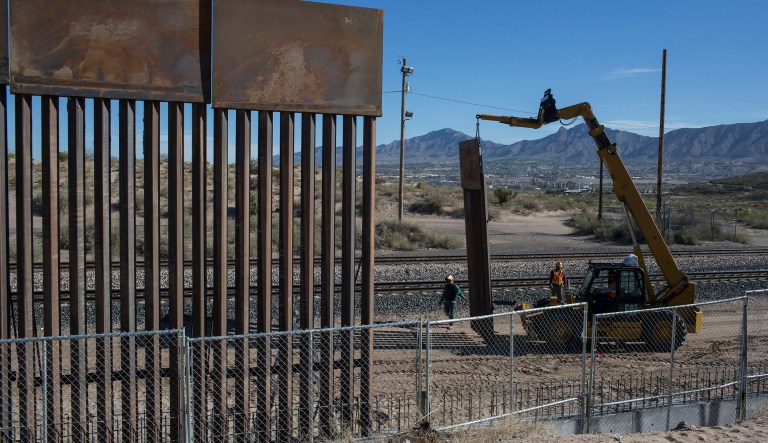 In this March 30, 2017 file photo, Workers use a crane to lift a segment of a new fence into place on the U.S. side of the border with Mexico, where Sunland Park, N.M., meets the Anapra neighborhood of Ciudad Juarez, Mexico. (AP Photo/Rodrigo Abd)
