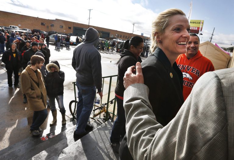 FILE - In this Jan. 1, 2014 file photo, marijuana store owner Toni Fox, right, greets customers who stand in a line numbering several hundred people, shortly after the opening of her 3D Cannabis Center, a recreational retail outlet in Denver. Colorado's new marijuana industry is in for a brand new element on Wednesday, Oct. 1, 2014 competition. The state gave existing medical marijuana dispensaries and growers like Fox's a nine-month exclusive on the new recreational pot business, fearing an unmanageable explosion of new businesses. (AP Photo/Brennan Linsley, file)