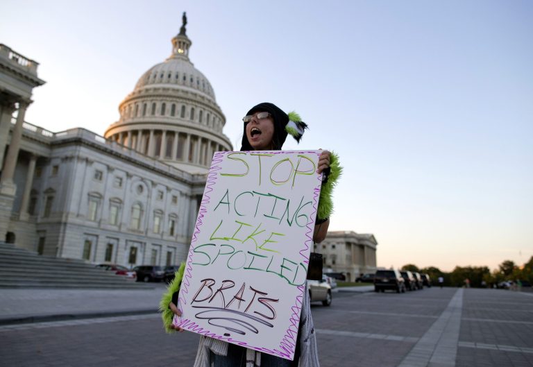Janette Dunder of Alexandria, Va., protests outside the Capitol building as Congress continues the budget battle Monday, Sept. 30, 2013, in Washington. President Barack Obama ramped up pressure on Republicans Monday to avoid a post-midnight government shutdown, saying that failure to pass a short-term spending measure to keep agencies operating would 
