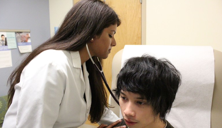 In this photo taken on Thursday, Nov. 19, 2015, American physician Meena Hasan examines a patient in her office in Gaithersburg, Md. (AP Photo/Noreen Nasir)