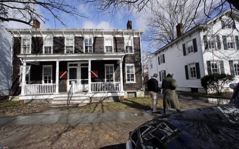Two men walk along along Alexander road in Princeton, N.J., Wednesday, Feb. 27, 2013, looking at empty houses with special markings. Princeton is giving away seven houses it needs to clear away in order to start a new development project. For free. But only if you can haul it out of Princeton. The homes boast details including Victorian scroll moulding and fireplaces. The catch is that most are in bad shape, with insulation peeking out from the foundation and broken shutters or railings. Moving a house can cost tens to hundreds of thousands of dollars. Kendal Siegrist of Wolfe Housing and Building Movers in Bernville, Penn., said the houses can't be carted away whole because there are too many utility lines, and it can cost $10,000 to move one line. (AP Photo/Mel Evans)