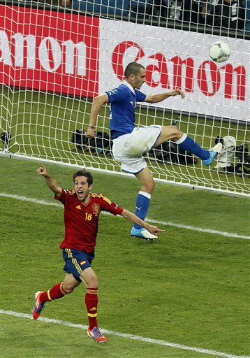 Spain's Jordi Alba celebrates scoring his side's second goal as Italy's Leonardo Bonucci kicks the ball in anger during the Euro 2012 soccer championship final  between Spain and Italy in Kiev, Ukraine, Sunday, July 1, 2012. (AP Photo/Vadim Ghirda)