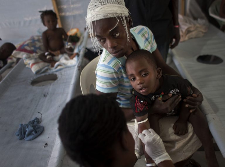 FILE - In this Oct. 19, 2011, file photo, a woman holds her sick child while he receives treatment for cholera at a Doctors Without Borders, MSF, cholera clinic in Port-au-Prince, Haiti. Top U.N. envoy Sandra Honore said this Monday March 24, 2014, that Haiti's cholera outbreak is still the worst in the world. Health officials in Haiti say the epidemic has killed more than 8,000 people. (AP Photo/Ramon Espinosa, File)