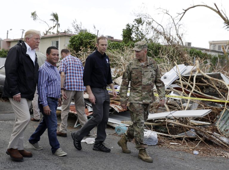 President Donald Trump walks with FEMA administrator Brock Long, second from right, and Lt. Gen. Jeff Buchanan, right as he tours an area affected by Hurricane Maria in Guaynabo, Puerto Rico, Tuesday, Oct. 3, 2017. Trump is visiting Puerto Rico in the wake of Hurricane Maria.(AP Photo/Evan Vucci)