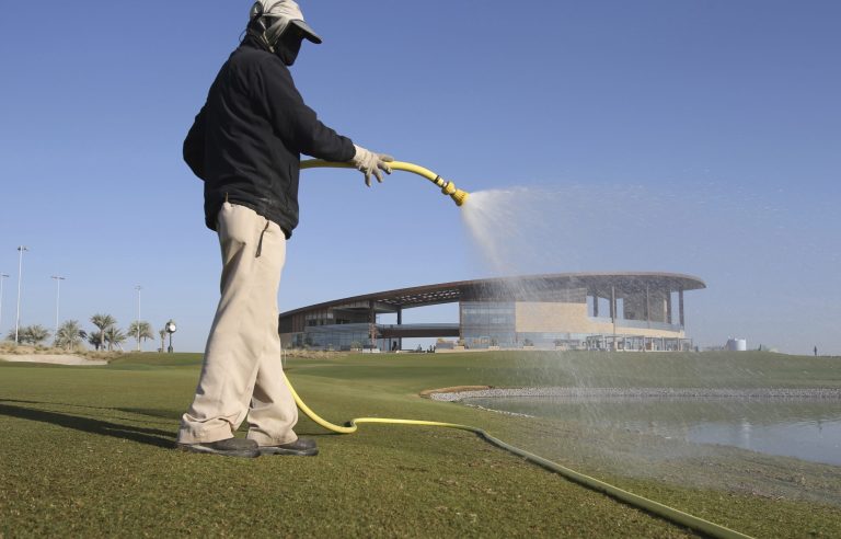 A gardener waters a green in front of the clubhouse at the Trump International Golf Club, in Dubai, United Arab Emirates. The 18-hole golf course in Dubai bearing Donald Trump's name exemplifies the questions surrounding his international business interests. (AP Photo/Kamran Jebreili)