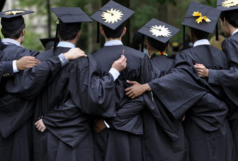 FILE - In this May 20, 2013 file photo, graduates pose for photographs during commencement at Yale University in New Haven, Conn.  The job market for new college graduates is brightening but remains weaker than before the Great Recession began. (AP Photo/Jessica Hill, File)