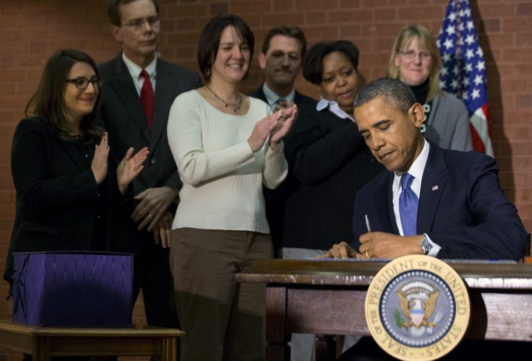 President Barack Obama signs the $1.1 trillion spending bill that funds the federal government through the end of September, in Washington, Friday, Jan. 17, 2014 at Jackson Place, a conference center near the White House. Obama signed the measure the day before federal funding was set to run out and was joined by aides who did much of the work negotiating it. (AP Photo/Jacquelyn Martin)