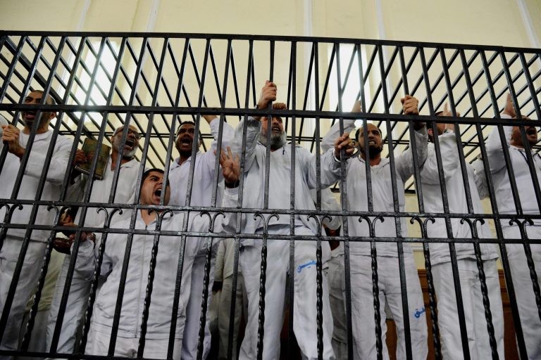 FILE - In this file photo taken Saturday, March 29, 2014, supporters of Egypt's ousted President Mohammed Morsi charged with violence chant slogans against the Egyptian military during a trial in court in Alexandria, Egypt. An Egyptian court sentenced 10 supporters of ousted President Mohammed Morsi's Muslim Brotherhood movement to death in absentia Saturday, June 7, on charges of inciting violence and blocking a road last July. (AP Photo/Heba Khamis, File)